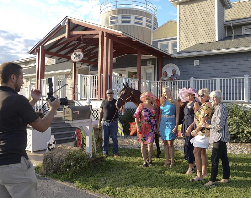 Children’s Beach House Event Committee member and Marketing Manager Justin Nixon lines up his shot of the committee. Shown are (l-r) Nixon, trainer Pete Marsh holding Changing Tides, Karen Bowers Falk, event chair; Cheryl Crowe, event co-chair; board members Pat Tosi, Connie Miller and Linda Fischer.